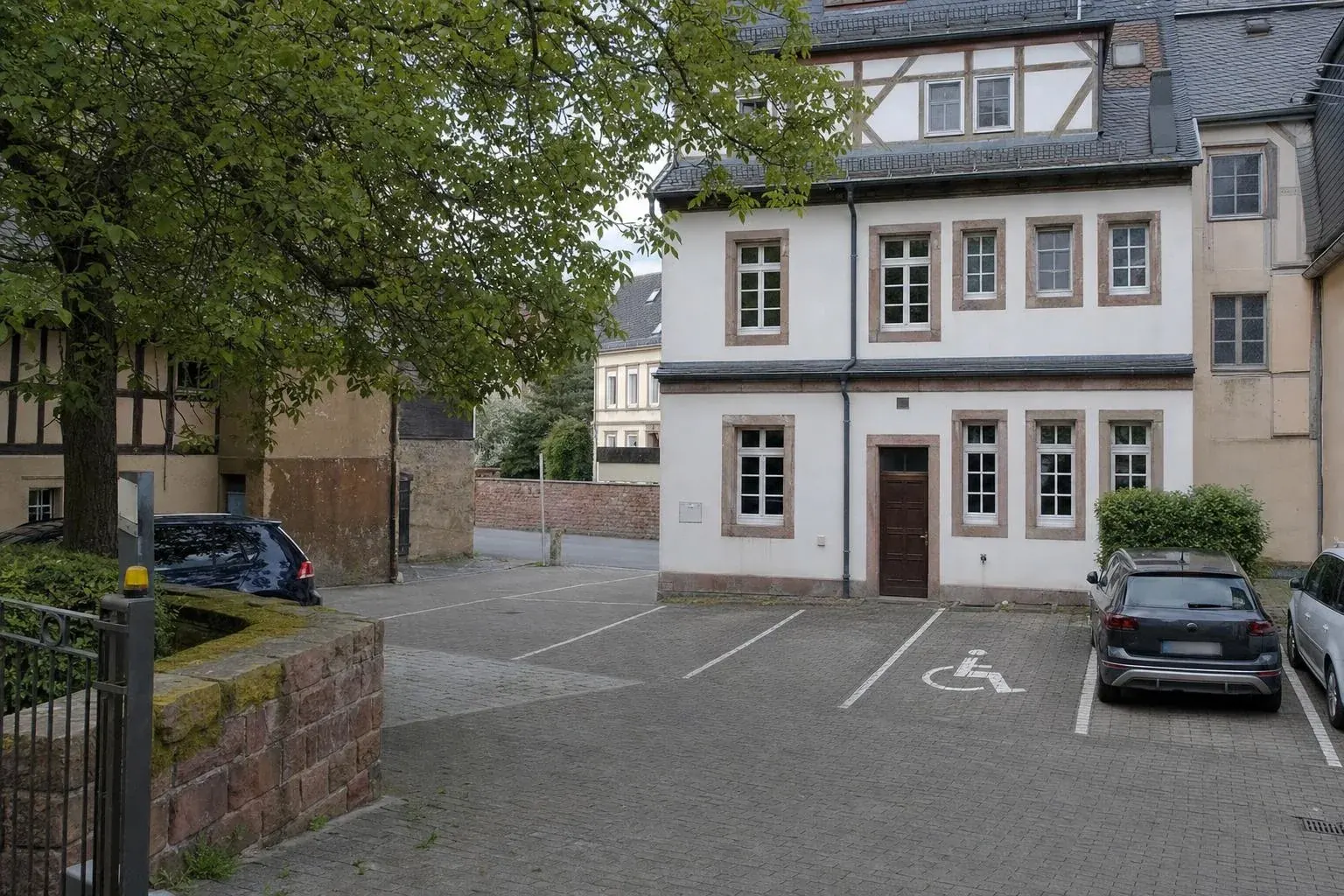 Parkplätze hinter dem Haus, darunter ein Behindertenparkplatz